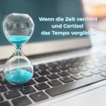 Sanduhr auf Laptop-Tastatur – Symbolbild für Cortisol und Stress, wenn die Zeit verrinnt und der Körper im Dauer-Alarmmodus steht.