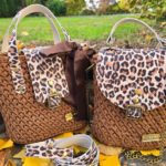 Handgefertigte braune Häkeltasche mit Lederriemen und feiner Struktur, fotografiert im Außenbereich.