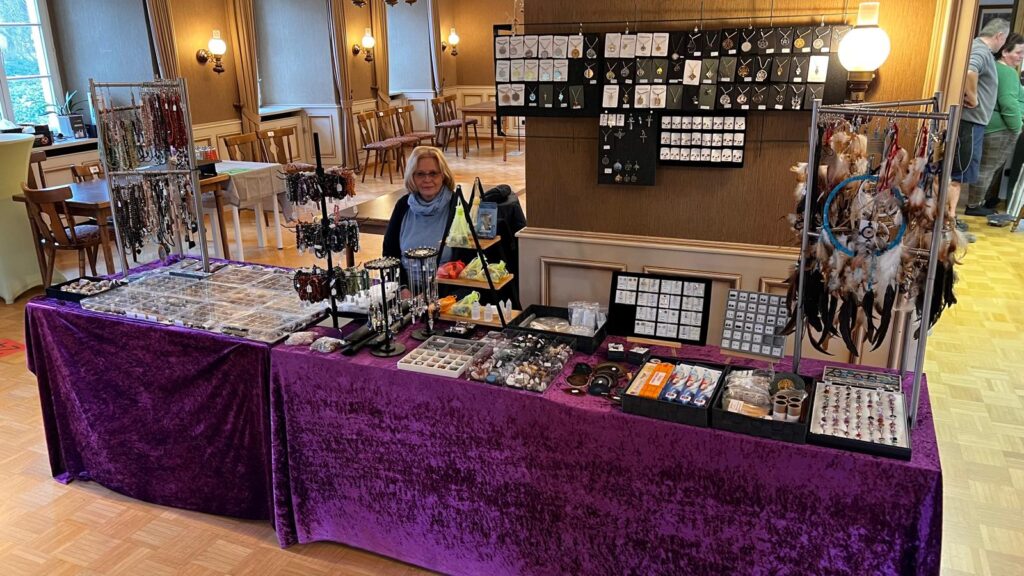 Stand von Conny Gaukesbrink mit Edelsteinen, Edelsteinschmuck, Runensteinen, Traumfängern und spirituellen Accessoires.
